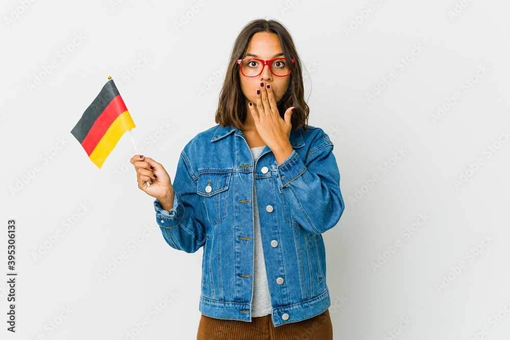 Young latin woman holding a german flag isolated on white background Young latin woman holding a german flag isolated on white background