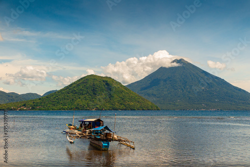 Scenic view of a boat on tropical ocean with vulcano in background, Ternate, Maluku, Indonesia
