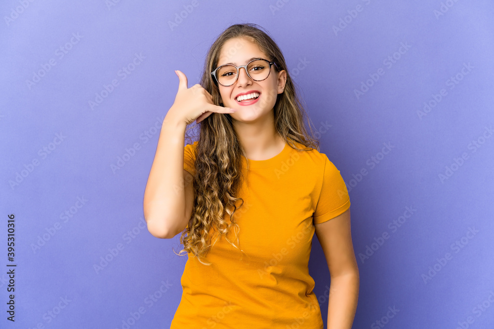 Young caucasian cute woman showing a mobile phone call gesture with fingers. Young caucasian cute woman showing a mobile phone call gesture with fingers.