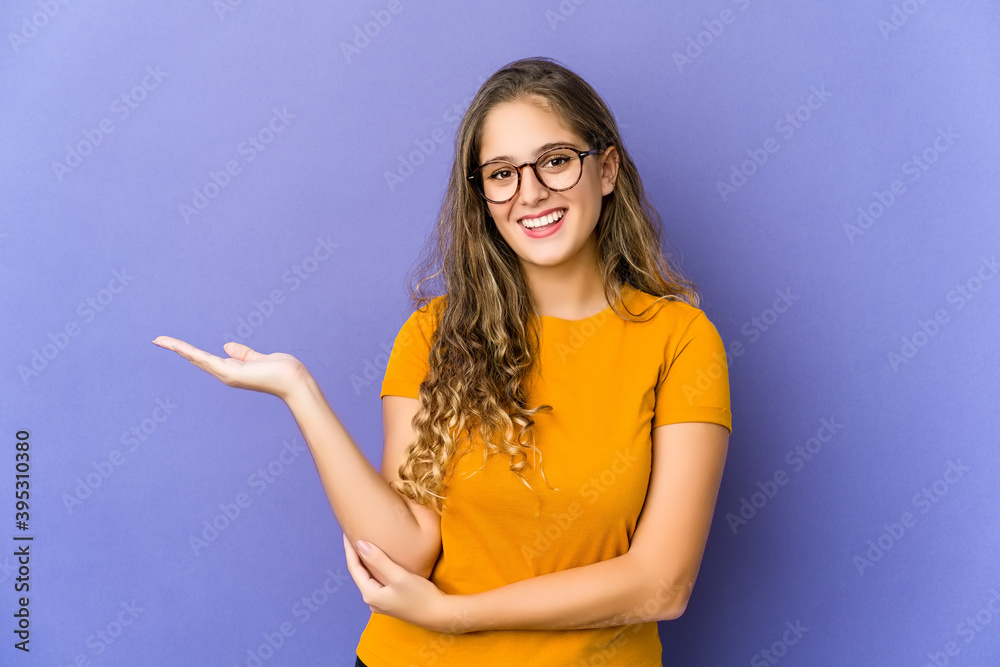 Young caucasian cute woman showing a copy space on a palm and holding another hand on waist. Young caucasian cute woman showing a copy space on a palm and holding another hand on waist.