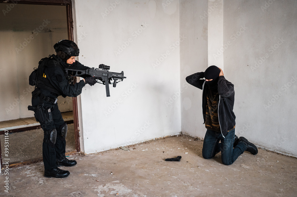 Fototapeta premium Man reenacting special unit of Croatian military police. Wearing green jumpsuit with black add-ons and assault rifle G36.