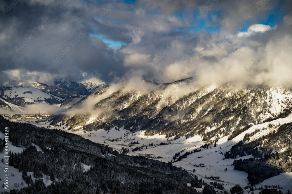 Wolken über den Bergen im Winter mit blauem Himmel