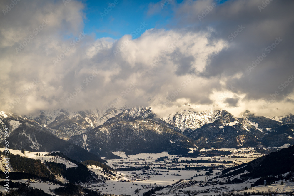 Wolkenstimmung im Winter über den Alpen mit blauem Himmel