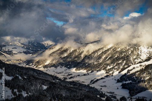 Wolken über den Bergen im Winter mit blauem Himmel