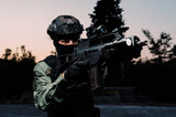 Man reenacting special unit of Croatian military police. Wearing green jumpsuit with black add-ons and assault rifle G36.