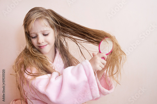 Bild auf Leinwand little girl combs her hair after a shower