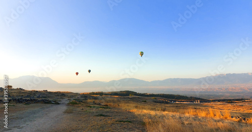 Hot air balloons in the blue sky over the valley at sunrise. High quality photo