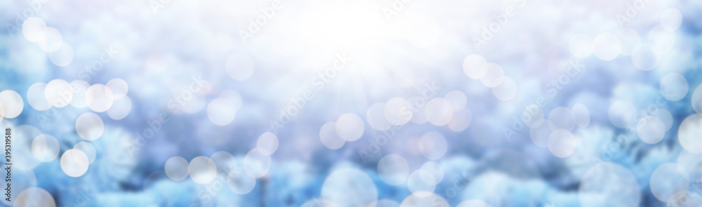Frozen winter Christmas landscape of an abstract blurred tree foliage with bright sunshine.