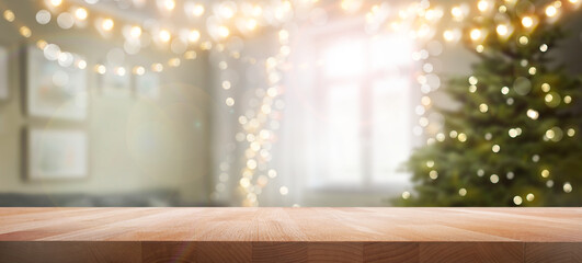 A wood table, tabletop product display with a festive Christmas background of Christmas tree and fairy lights.