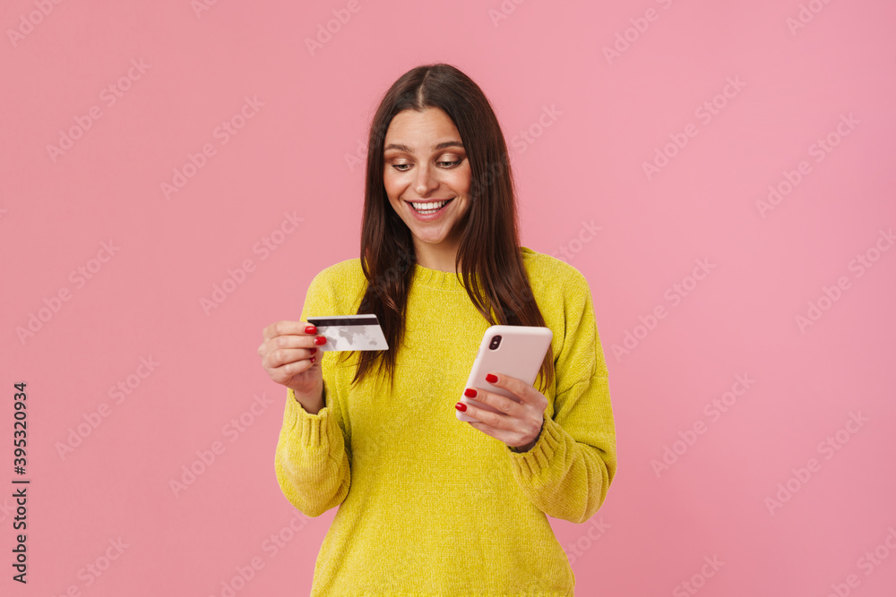 Joyful brunette girl posing with cellphone and credit card Joyful brunette girl posing with cellphone and credit card
