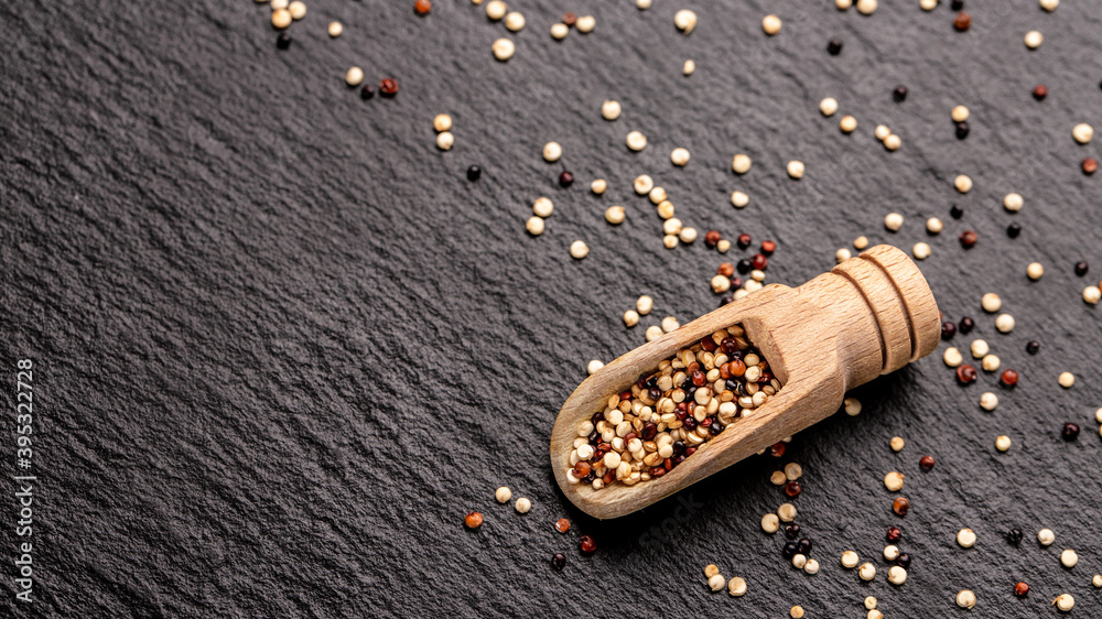 Mixed quinoa red, white and brown quinoa in wooden scoop. Healthy and diet superfood product. banner, menu, recipe, place for text. top view Mixed quinoa red, white and brown quinoa in wooden scoop. Healthy and diet superfood product. banner, menu, recipe, place for text. top view