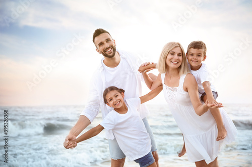 Happy family having fun on beach near sea