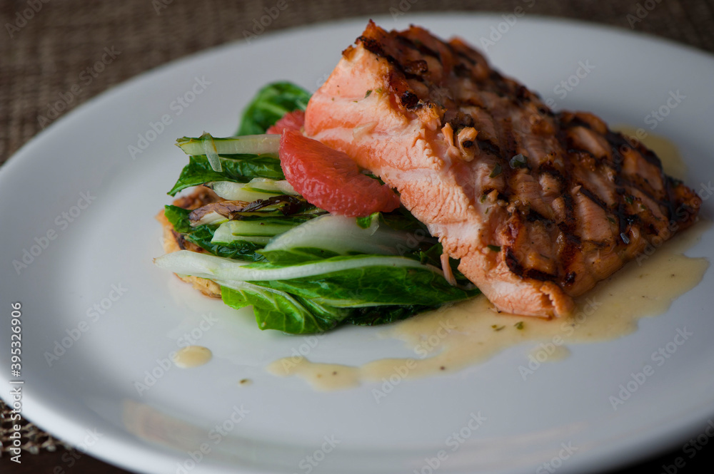 Salmon steak. Salmon grilled in olive oil, topped with almonds, scallions and Italian parsley. Served with garlic Brussel sprouts. Classic American restaurant or French bistro entree.