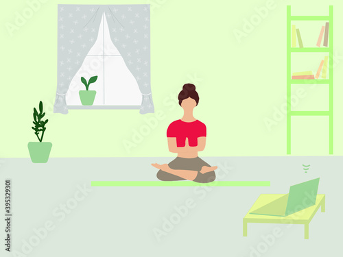 A woman does yoga at home on a video lesson from a computer. Lessons with a trainer online. Sports lifestyle.