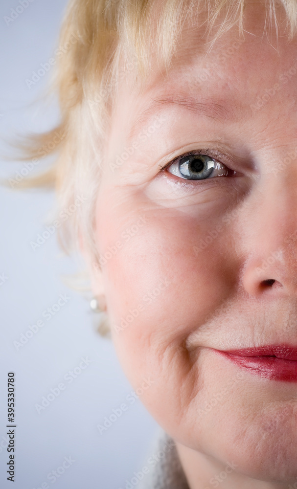 Close up studio portrait of blonde senior woman looking at camera wearing red lipstick. Close up studio portrait of blonde senior woman looking at camera wearing red lipstick.