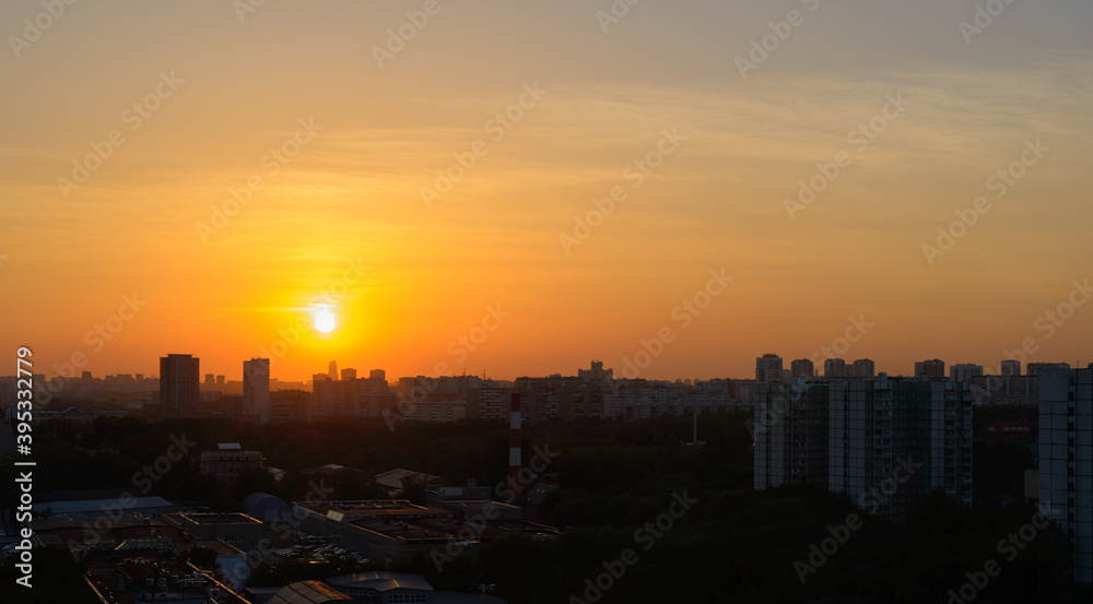 Fototapeta premium Summer sunset orange sun over a large city