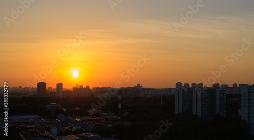 Summer sunset orange sun over a large city