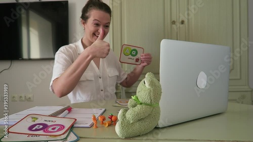 Portrait of professional young, female English teacher. Teaching children English phonetics on wireless internet. 