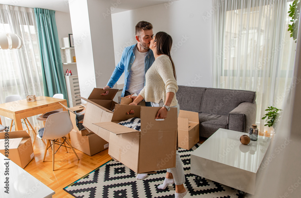 Smiling young couple move into a new home carrying boxes of belongings. Smiling young couple move into a new home carrying boxes of belongings.