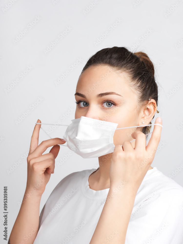 Young woman showing how to wear a medical mask step by step