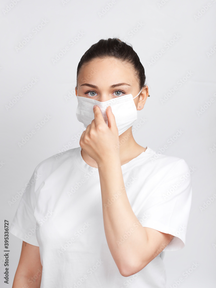 Young woman showing how to wear a medical mask step by step