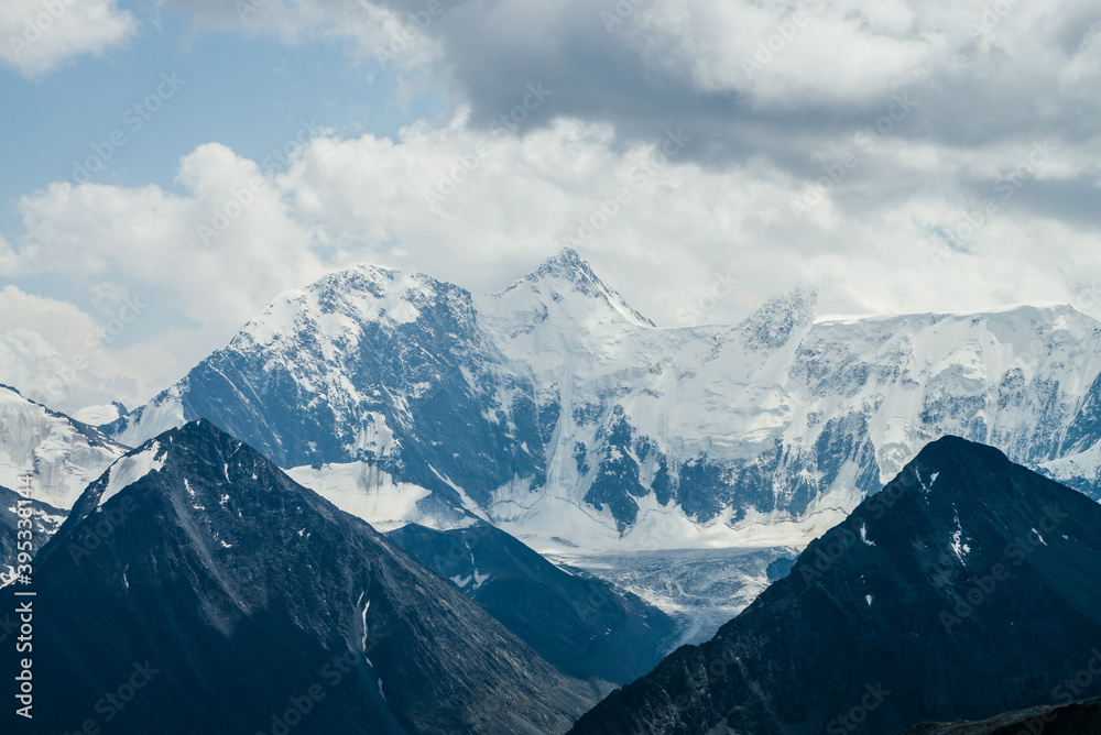 Awesome landscape with beautiful huge glacial mountains in overcast weather. Wonderful snowy mountain with glaciers under cloudy sky. Gloomy overcast atmospheric scenery with big rocks and glaciers.