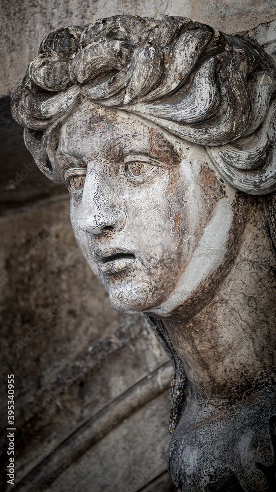 Facade ancient sculpture of beautiful Venetian woman as decoration of Doge Palace in Venice, Italy
