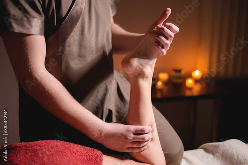 Wallpaper Mural Professional massage of female feet by a man masseur in a dark spa salon with candles Torontodigital.ca