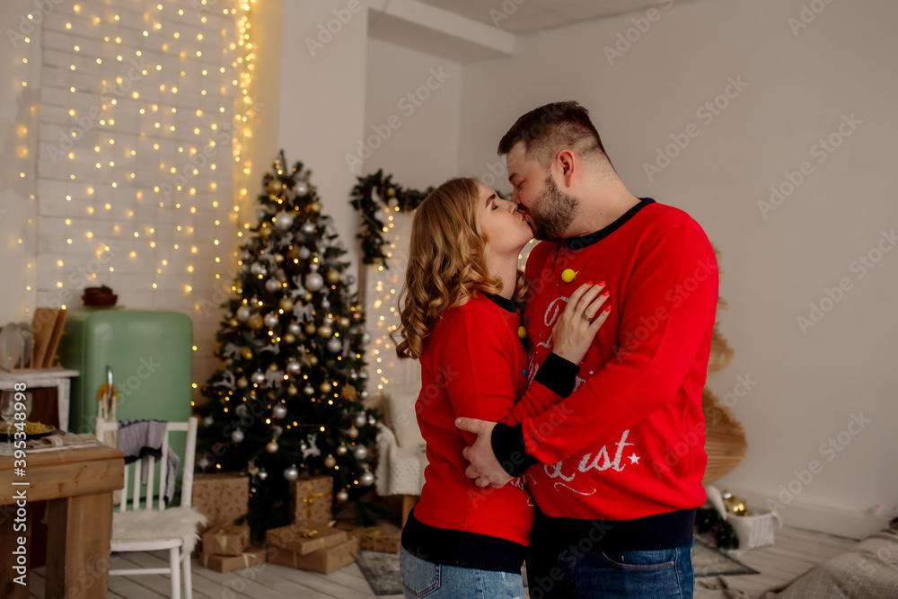 Young caucasian couple man and woman hugging and laughing while standing at home in living room with christmas tree
Young caucasian couple man and woman hugging and laughing while standing at home in living room with christmas tree