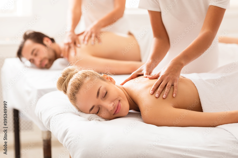 Relaxed Spouses Enjoying Massage Lying On Beds At Spa Center Relaxed Spouses Enjoying Massage Lying On Beds At Spa Center