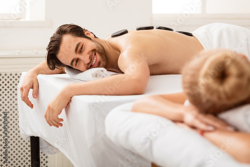 Couple Enjoying Stone Massage Lying And Relaxing At Spa Salon