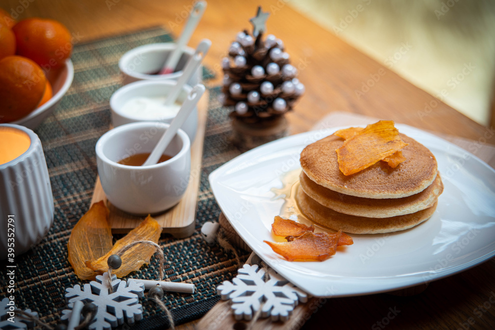 Festive table setting with vegane pancakes and tangerines Festive table setting with vegane pancakes and tangerines