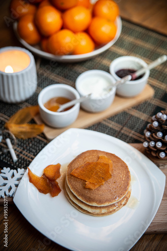 Festive table setting with vegane pancakes and tangerines