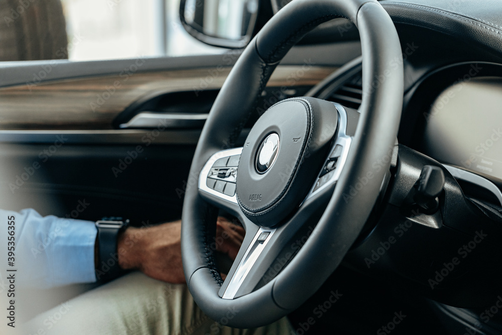 Male hands holding steering wheel of a car Male hands holding steering wheel of a car