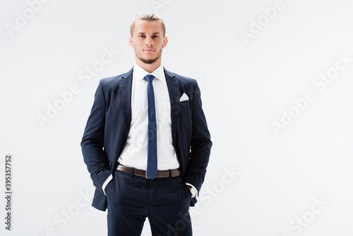  businessman in suit posing with hands in pockets isolated on white