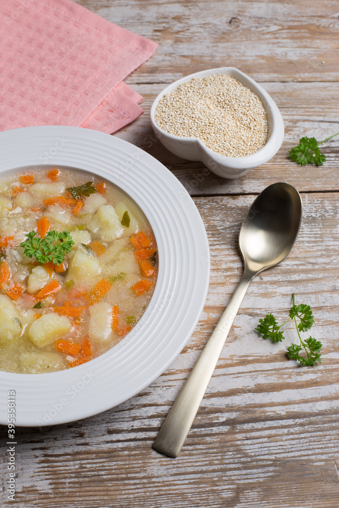 Vegetarian quinoa soup with carrots, potatoes and onions, sprinkled with parsley in a white plate. Vegetable soup with gluten-free quinoa. Vegetarian quinoa soup with carrots, potatoes and onions, sprinkled with parsley in a white plate. Vegetable soup with gluten-free quinoa.