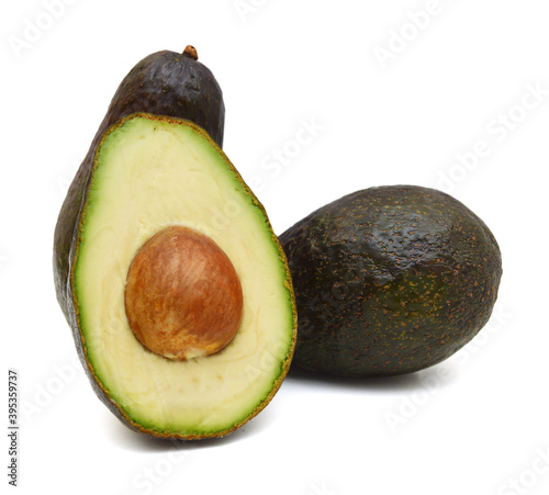 Whole and half avocado isolated on white.