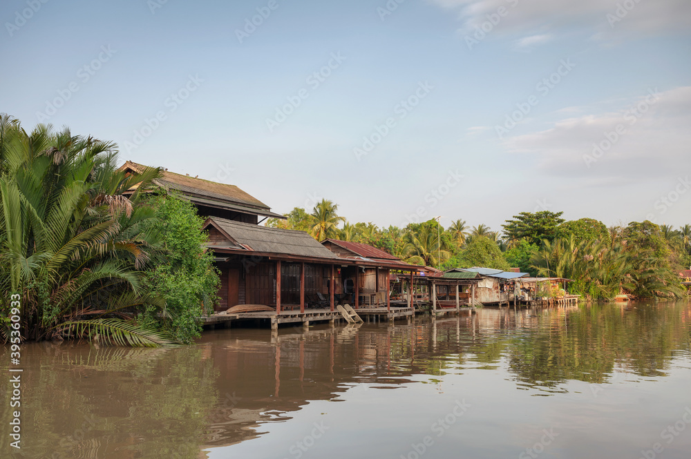 Wooden homestay floating on riverside in the evening at Amphawa