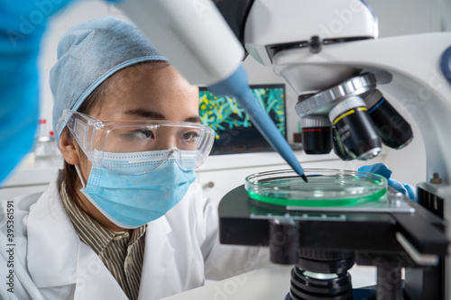 Gros plan sur les yeux d'une femme asiatique chercheur avec pipette et microscope.