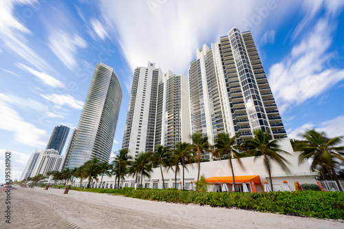 Long exposure daytime photo highrise towers on the beach motion blur in sky and palms © Felix Mizioznikov