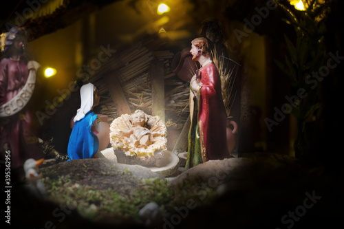 Christmas nativity scene - Jesus Christ, Mary and Joseph. Wooden figurines, donkey in the background.