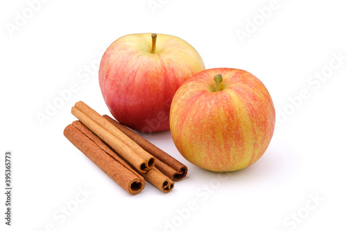 Two apples and cinnamon sticks isolated on a white background.