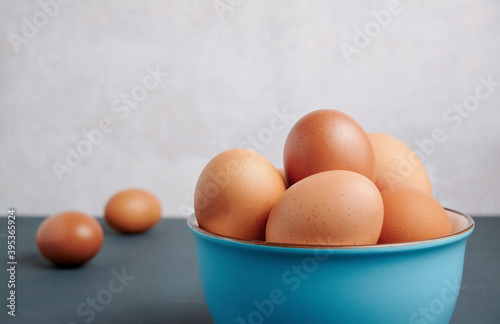 Fresh eggs in a blue bowl with copy space