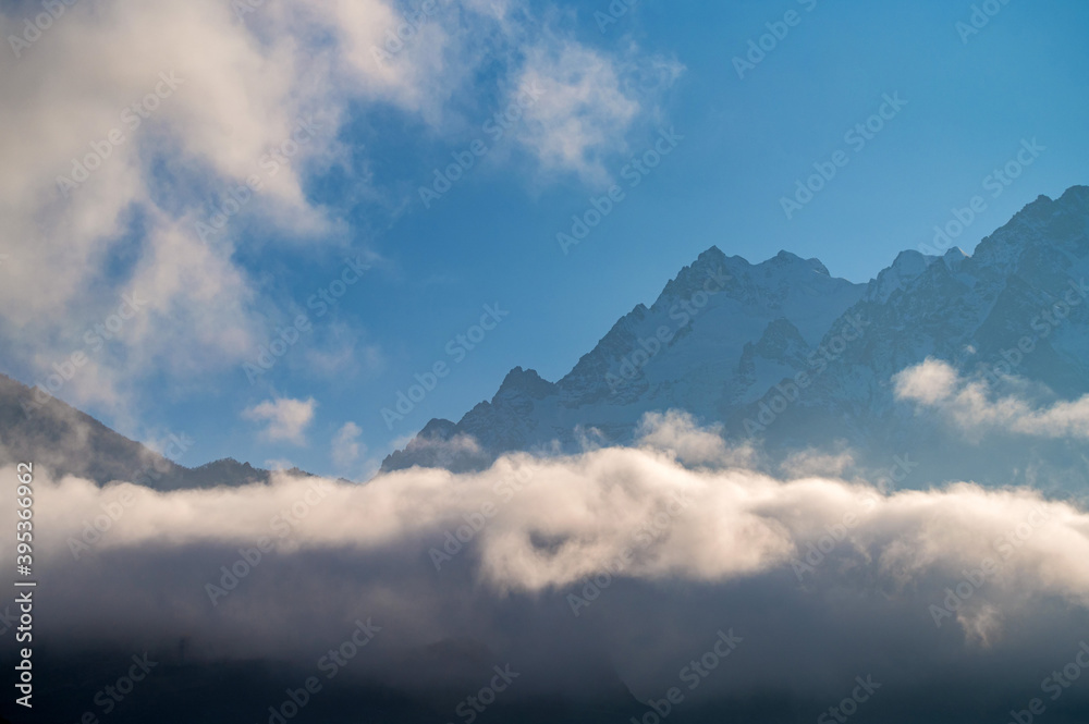 Rocks behind clouds in North Caucasus mountains in autumn on sunny day Rocks behind clouds in North Caucasus mountains in autumn on sunny day