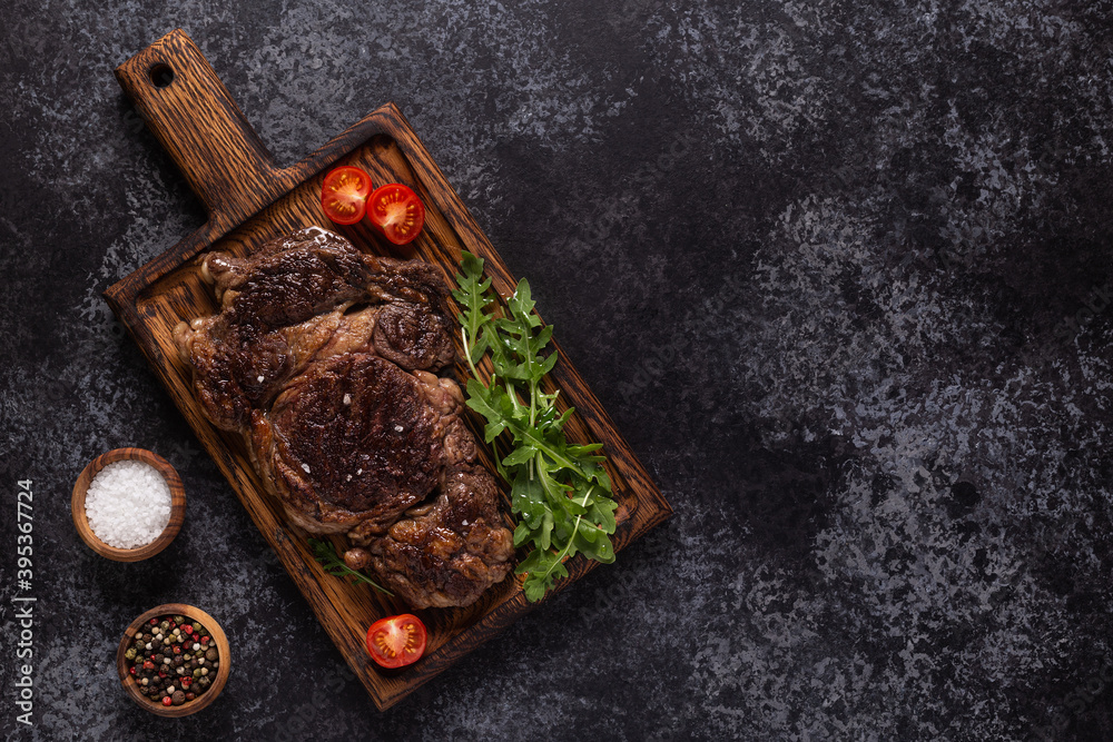 Grilled beef steak with spices on a wooden board. Grilled beef steak with spices on a wooden board.