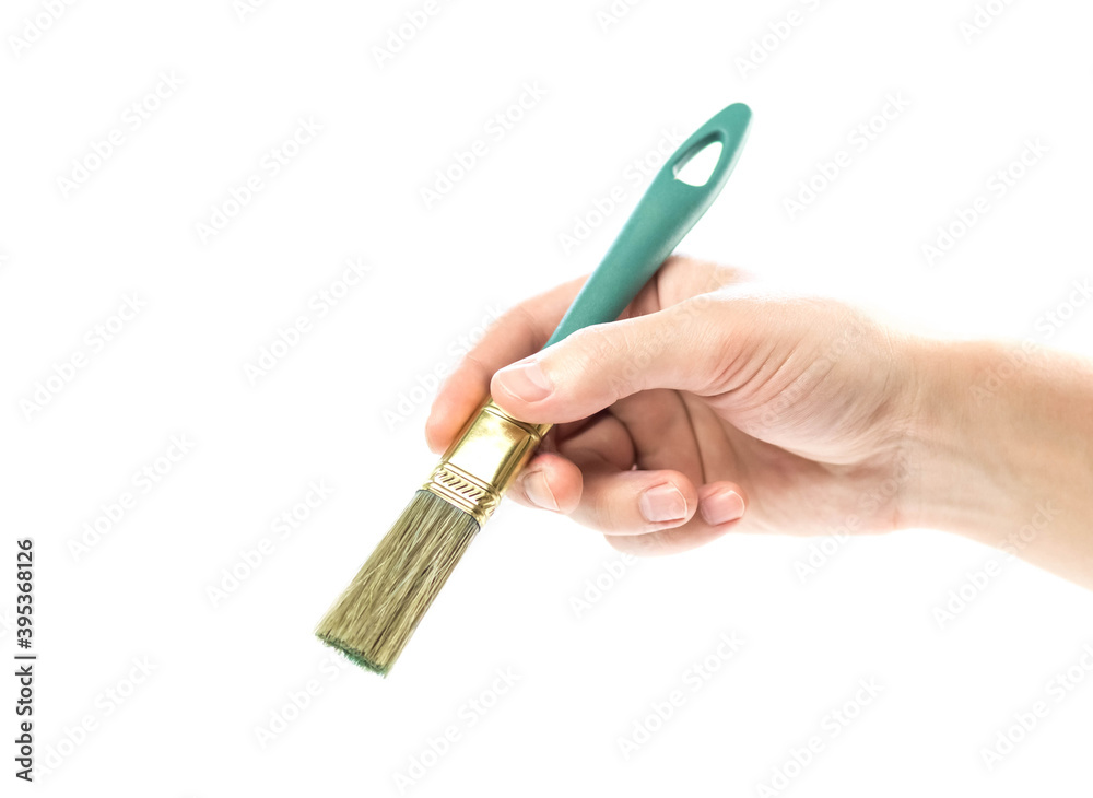 Hand holding a paint brush. Close up. Isolated on a white background Hand holding a paint brush. Close up. Isolated on a white background