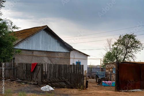 House in countryside with a tiled roof and a broken wooden fence