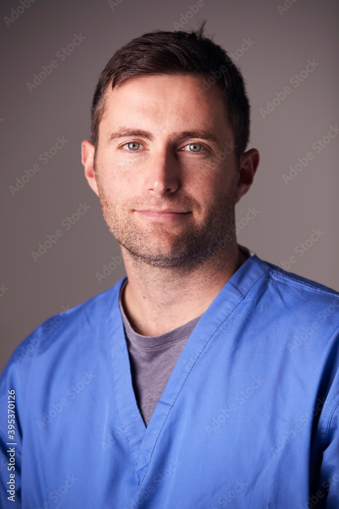 Obraz premium Studio Portrait Of Male Nurse Wearing Scrubs Standing Against Grey Background