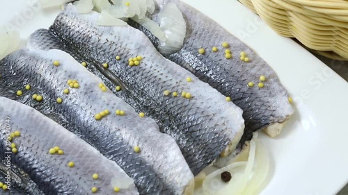 Traditional Dutch sour herring with onions and mustard seed close up photo