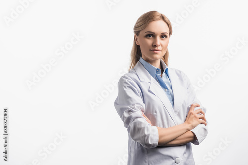Foto nurse in white coat standing with crossed arms isolated on white